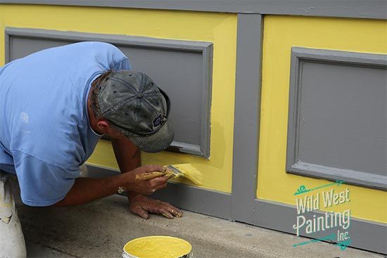 Interior painting - Painter painting a wall yellow.